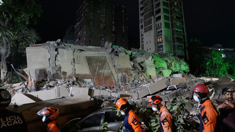 Trabajadores de rescate buscan entre los escombros de un edificio derruido tras un sismo, el...
