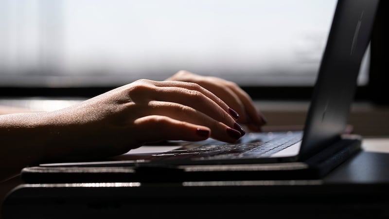 Una mujer trabaja en una laptop en un tren en Nueva Jersey, el 18 de mayo del 2021. (AP...